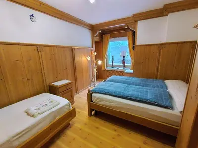 a bedroom with two beds and a window at Appartamento Bill Sottoguda in Sottoguda