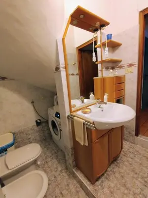 a bathroom with a sink and a toilet and a mirror at Appartamento Bill Sottoguda in Sottoguda