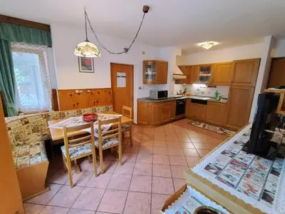 a kitchen with a table and chairs in a room at Appartamento Bill Sottoguda in Sottoguda