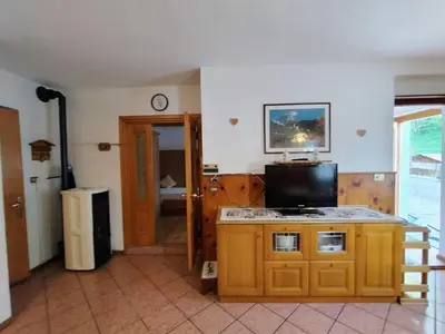 a room with a kitchen with a tv on a counter at Appartamento Bill Sottoguda in Sottoguda