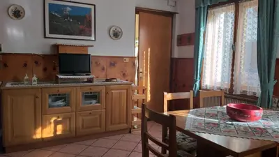 a kitchen and dining room with a table and a table and a table at Appartamento Bill Sottoguda in Sottoguda