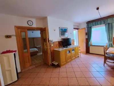 a living room with a television and a room with at Appartamento Bill Sottoguda in Sottoguda