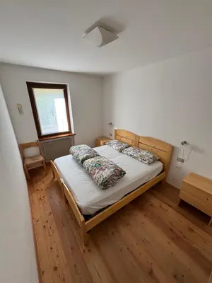 a bedroom with a bed and a window at Il Cirmolo in Canale dʼAgordo