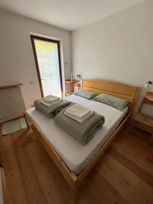 a bedroom with a large bed with towels on it at Il Cirmolo in Canale dʼAgordo