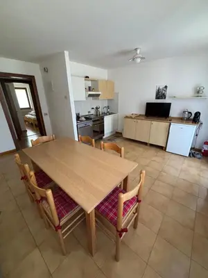 a kitchen with a wooden table and chairs in a room at Il Cirmolo in Canale dʼAgordo