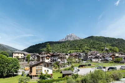 a village with a mountain in the background at Sass Maor - Caminetto in Transacqua