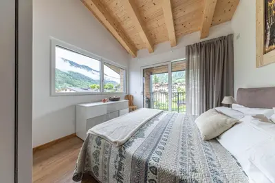 a bedroom with a bed and a large window at Pavione - Caminetto in Transacqua