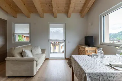 a living room with a couch and a table at Pavione - Caminetto in Transacqua