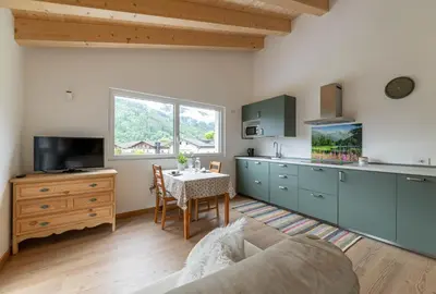a kitchen with blue cabinets and a table in a room at Pavione - Caminetto in Transacqua