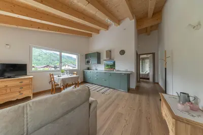 a living room with a couch and a table at Pavione - Caminetto in Transacqua