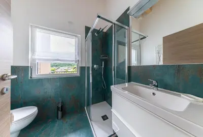 a bathroom with a shower and a sink and a toilet at Pavione - Caminetto in Transacqua