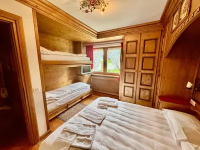 a bedroom with two bunk beds and a window at Dolomiti quiet apartment with garden - San Vito in San Vito di Cadore