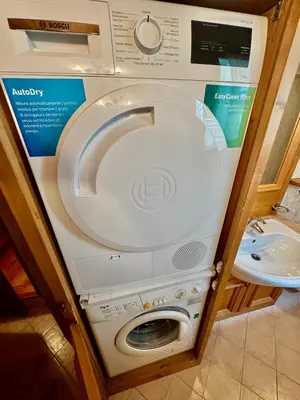 a washing machine in a bathroom with a sink at Dolomiti quiet apartment with garden - San Vito in San Vito di Cadore