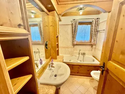 a bathroom with a sink and a tub and a toilet at Dolomiti quiet apartment with garden - San Vito in San Vito di Cadore