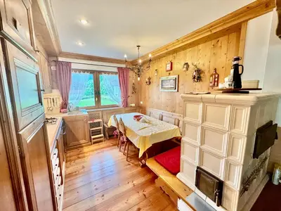 a kitchen with a table and a dining room at Dolomiti quiet apartment with garden - San Vito in San Vito di Cadore