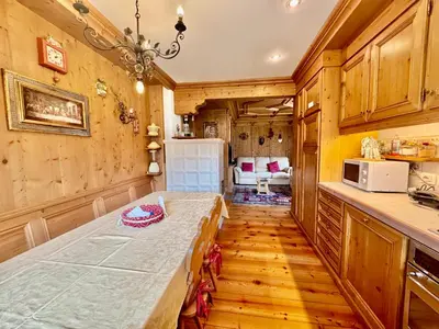 a kitchen with a long table in a room at Dolomiti quiet apartment with garden - San Vito in San Vito di Cadore