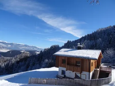 a house on a hill with the sun shining on it at EGGA nature deluxe apartments - Panorama & Wellness, Kiens, Pustertal in Chienes