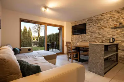 a living room with a couch and a table at Sirona Stay - Private Spa Retreat near Bolzano Dolomites - Romantic Stay with Sauna Whirlpool Garden Garage Free Bolzano Card in San Genesio Atesino