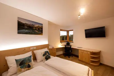 a bedroom with a bed and a desk with a computer at Sirona Stay - Private Spa Retreat near Bolzano Dolomites - Romantic Stay with Sauna Whirlpool Garden Garage Free Bolzano Card in San Genesio Atesino