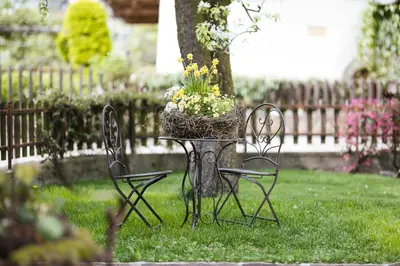 a table with a basket of flowers on it in a yard at Stammhaus Vetterer in Lana