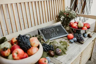 a table with bowls of fruit and a sign on it at Stammhaus Vetterer in Lana