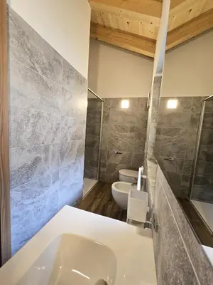a bedroom with a bed in a room with wooden ceilings at Miravalli Home in Gosaldo