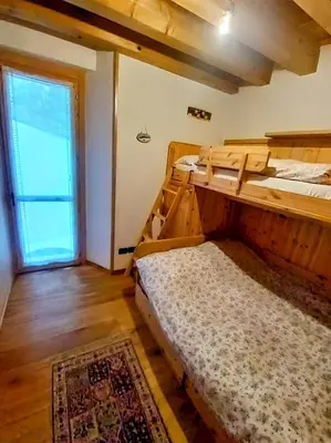 a room with two bunk beds and a window at Beautiful apartment in Zoldo Alto Dolomites in Pianaz