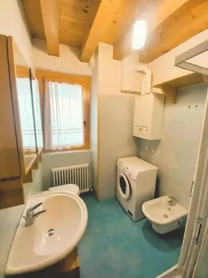 a bathroom with a sink and a washing machine at Beautiful apartment in Zoldo Alto Dolomites in Pianaz