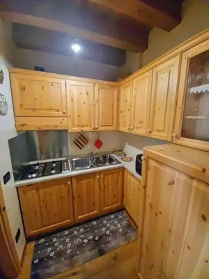 a small kitchen with wooden cabinets and a sink at Beautiful apartment in Zoldo Alto Dolomites in Pianaz