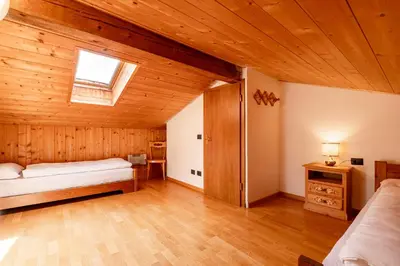 a bedroom with wooden walls and a wooden ceiling at Un respiro nel bosco - Residence Cèsa Da Mont in Penia