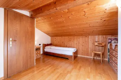 a bedroom with a bed and a wooden ceiling at Un respiro nel bosco - Residence Cèsa Da Mont in Penia