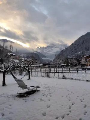 a chair sitting in the snow next to a fence at Il Giardino dell'Eden in Caprile