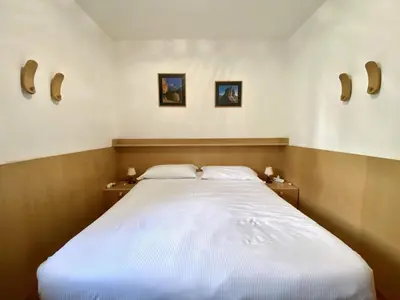 a bedroom with a large bed with two pillows at Cozy flat in amazing central location in Cortina dʼAmpezzo