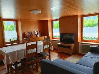 a living room with a table and a tv at La Casetta in San Vito di Cadore