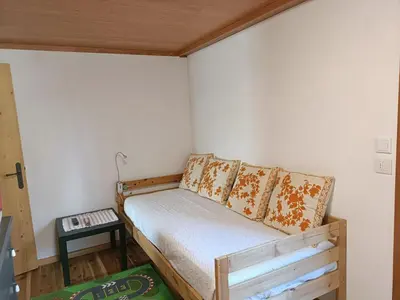 a small bedroom with a bed and a table at La Casetta in San Vito di Cadore
