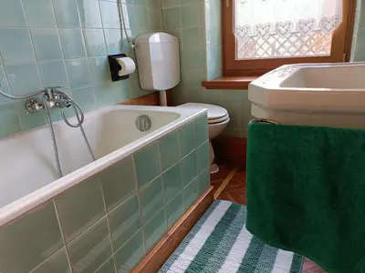 a bathroom with a toilet and a tub and a sink at La Casetta in San Vito di Cadore