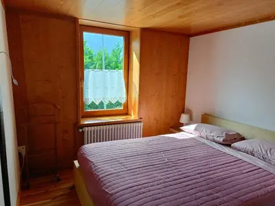 a bedroom with a bed and a window at La Casetta in San Vito di Cadore