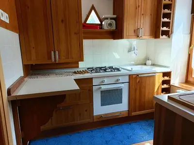 a kitchen with wooden cabinets and a stove top oven at La Casetta in San Vito di Cadore