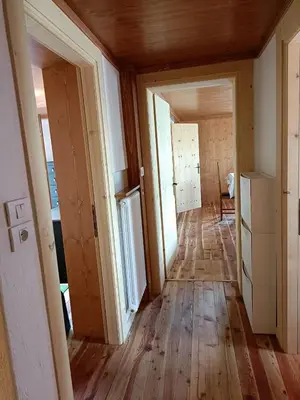 an empty hallway in a house with wooden floors and doors at La Casetta in San Vito di Cadore