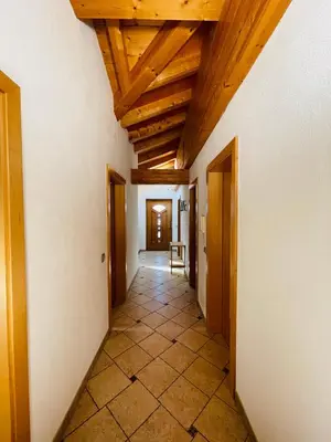 a hallway with wooden ceilings and a room with a table at Apartment Oberhauserhof in Falzes