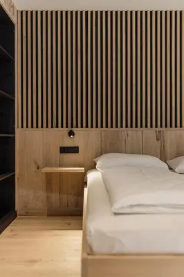 a bedroom with two beds and a wall with stripes at Hochegg Hideaway in Laives