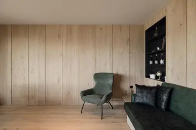 a living room with a green couch and a chair at Hochegg Hideaway in Laives