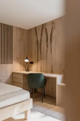 a bedroom with a desk and a bed and a chair at Hochegg Hideaway in Laives