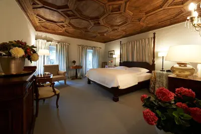 a bedroom with a large bed with a wooden ceiling at Schloss Englar in Appiano sulla Strada del Vino