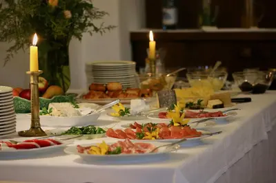 a long table with plates of food and candles at Schloss Englar in Appiano sulla Strada del Vino