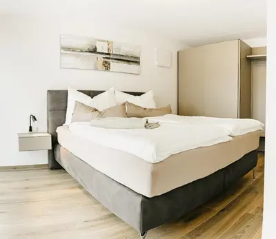 a bedroom with a large bed with white sheets at Suite by Silvy in Vipiteno