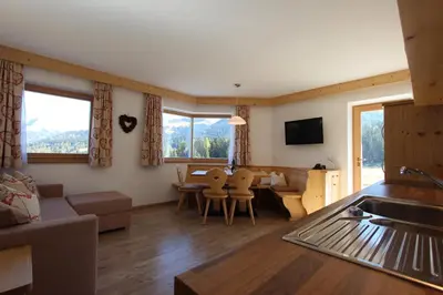a living room with a couch and a table and chairs at Apartments DAMONT in Santa Cristina in Val Gardena