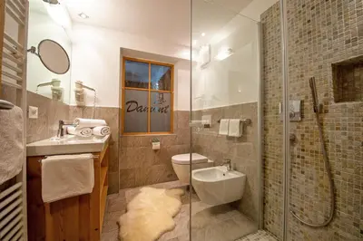 a bathroom with a toilet and a sink and a shower at Apartments DAMONT in Santa Cristina in Val Gardena