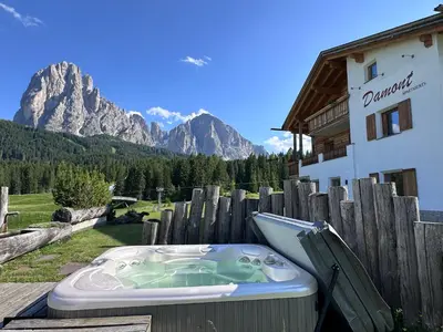 a bedroom with a large bed with a wooden headboard at Apartments DAMONT in Santa Cristina in Val Gardena