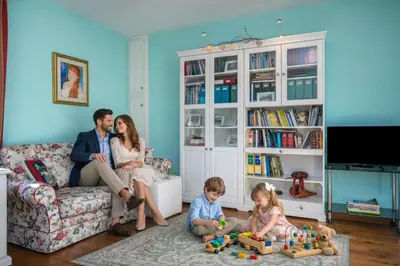 a family sitting in a living room playing with toys at Ciasa Marian 10 minutes from Cortina with free parking! in Borca di Cadore